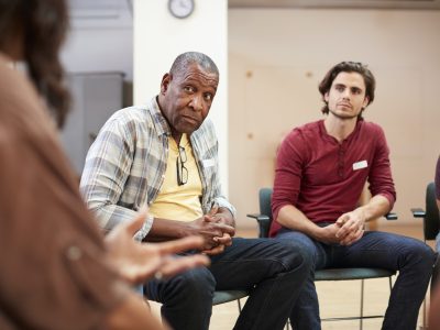 People Attending Self Help Therapy Group Meeting In Community Center People Attending Self Help Therapy Group Meeting In Community Center