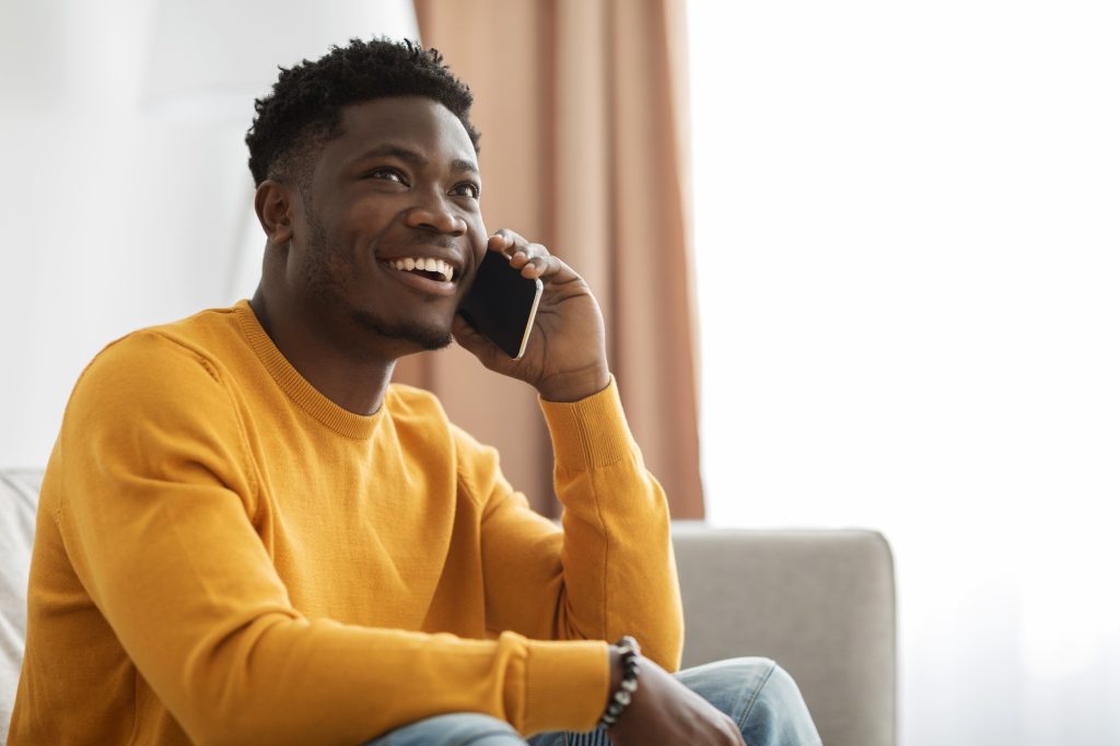 Handsome african american young man having phone conversation with girlfriend