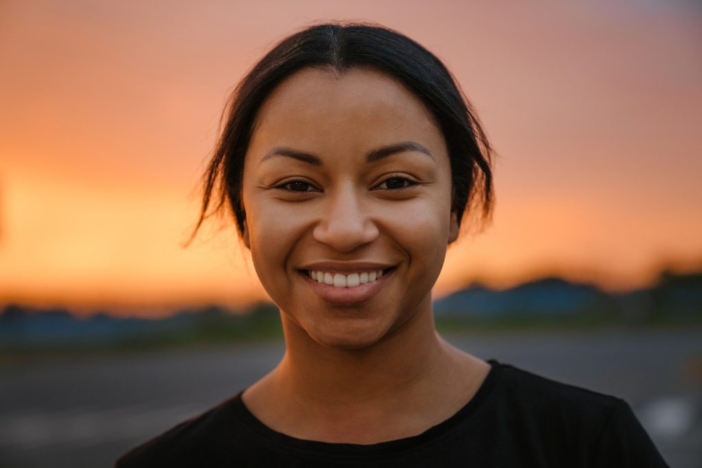 Black brunette woman smiling and looking at camera