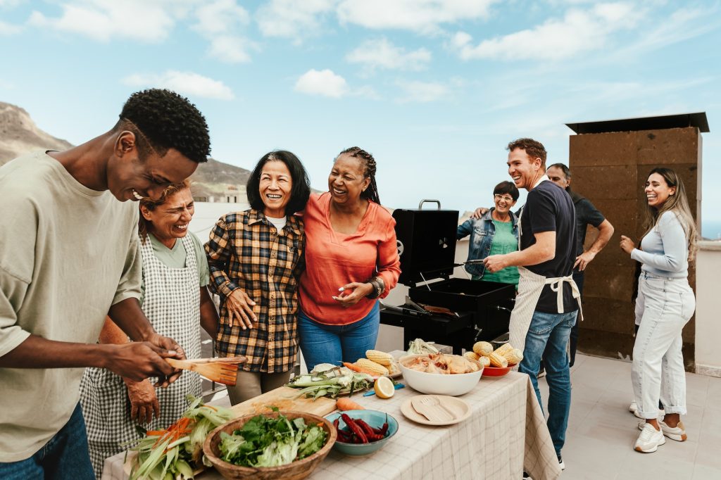 Happy multigenerational people having fun doing barbecue grill at house rooftop