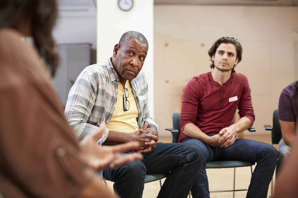 People Attending Self Help Therapy Group Meeting In Community Center
